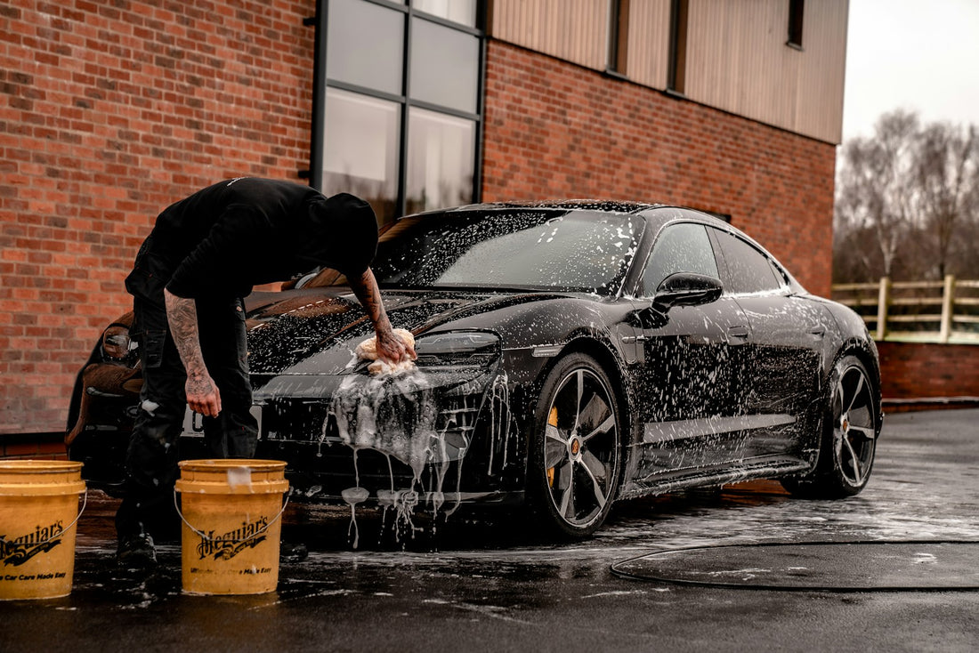 Detailer drying a freshly washed car